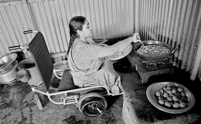 En fysiskt utmanad kvinna lagar mat åt sina kollegor på The Center for the Rehabilitation of the Paralysed, CRP i Savar, Dhaka, Bangladesh. 2005.